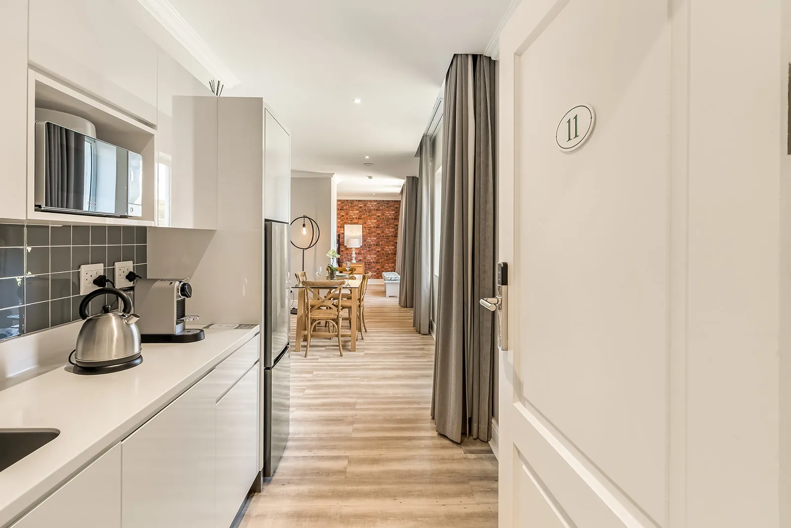 Open-plan kitchen and dining with exposed-brick feature wall and natural light | Studio Stay on Sixty6 boutique hotel & accommodation in Sandton